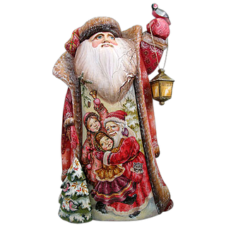 A hand-painted Santa Claus figurine with a lantern, featuring a Christmas tree and two children in the background.