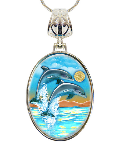 A pendant necklace with a circular design featuring two dolphins leaping out of the water against a backdrop of a sunset and ocean waves.