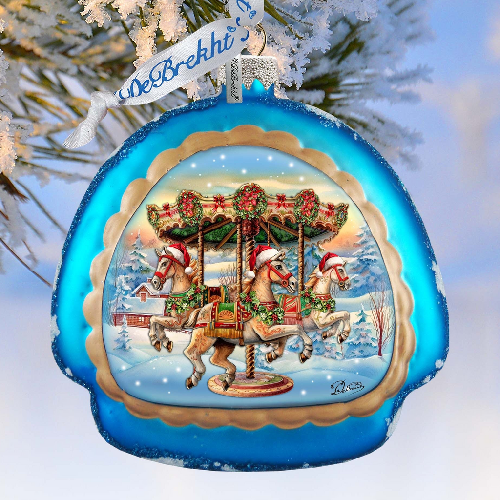 A blue ornament with a carousel scene featuring horses and a Christmas tree.