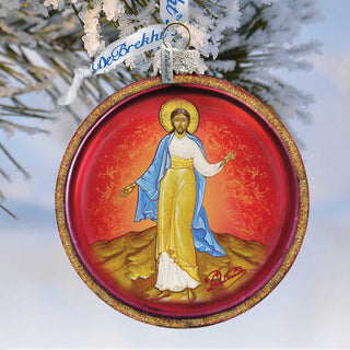A circular ornament featuring a religious figure, likely a saint or deity, with a halo and a blue robe, set against a red and gold background.