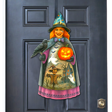 A Halloween-themed door decoration featuring a witch holding a jack-o-lantern and a black crow.