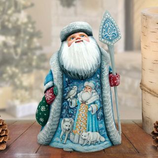 A figurine of Santa Claus holding a snowshoe and a reindeer, with a wreath and pine cones in the background.