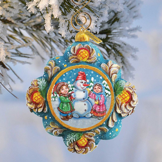 A colorful ornament featuring a snowman, two children, and a snowy landscape, hanging from a tree branch.