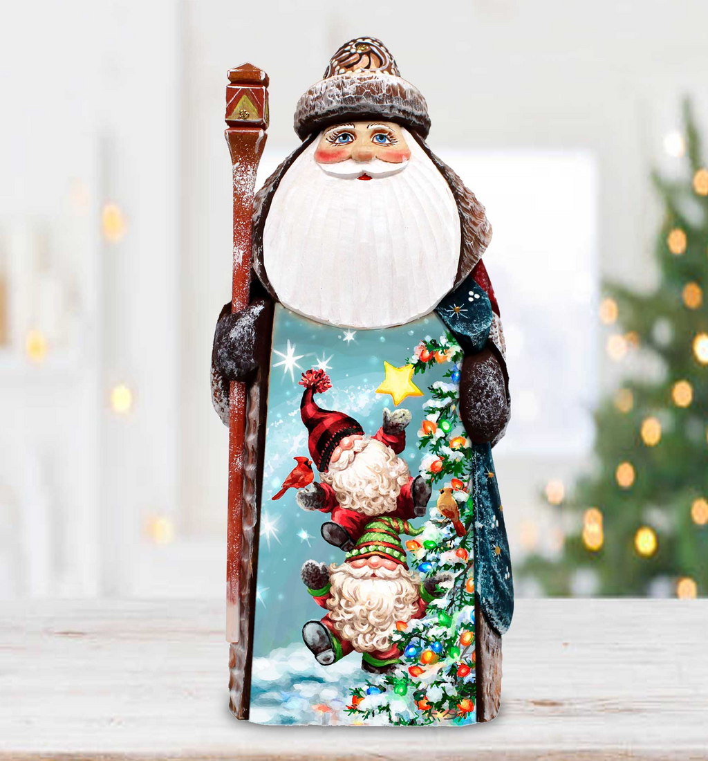 A wooden Santa Claus figurine holding a star and a gnome, set against a blurred background with Christmas lights visible.
