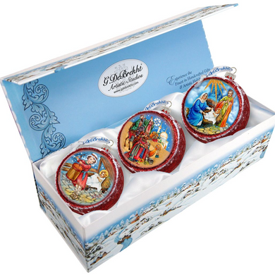 A set of three decorative Christmas ornaments in a box, each featuring a different scene from the nativity story.