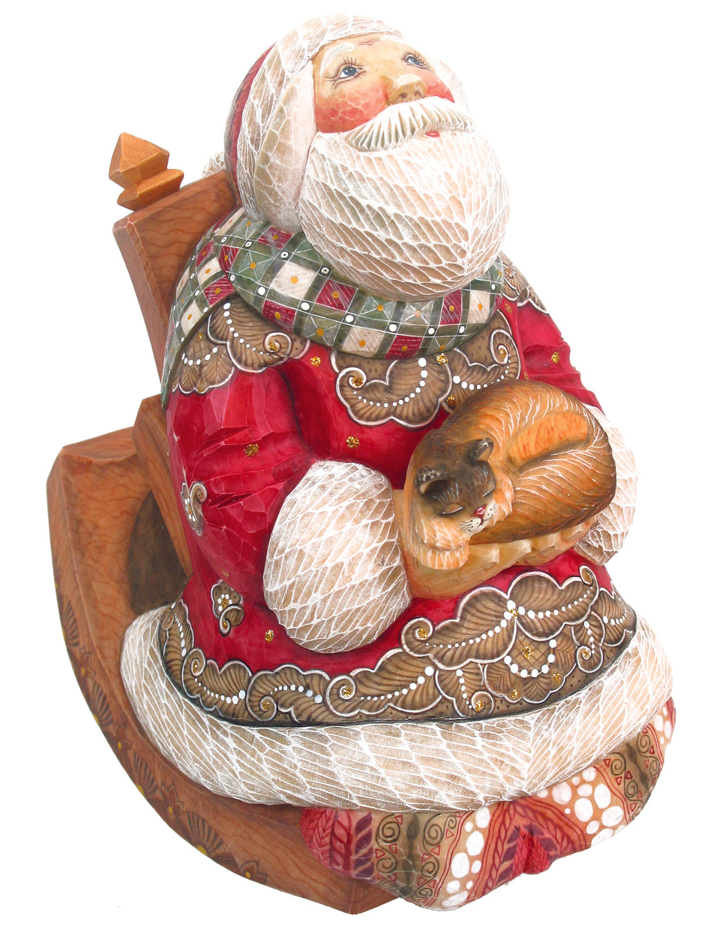A wooden statue of Santa Claus sitting on a rocking chair, holding a small brown cat in his lap.