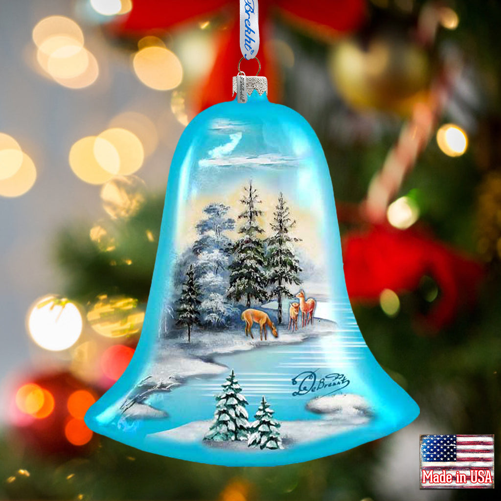 a glass bell ornament with a christmas scene on it
