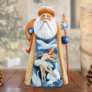 A wooden Santa Claus figurine with a painted design of a ballerina and swans, standing on a wooden surface.