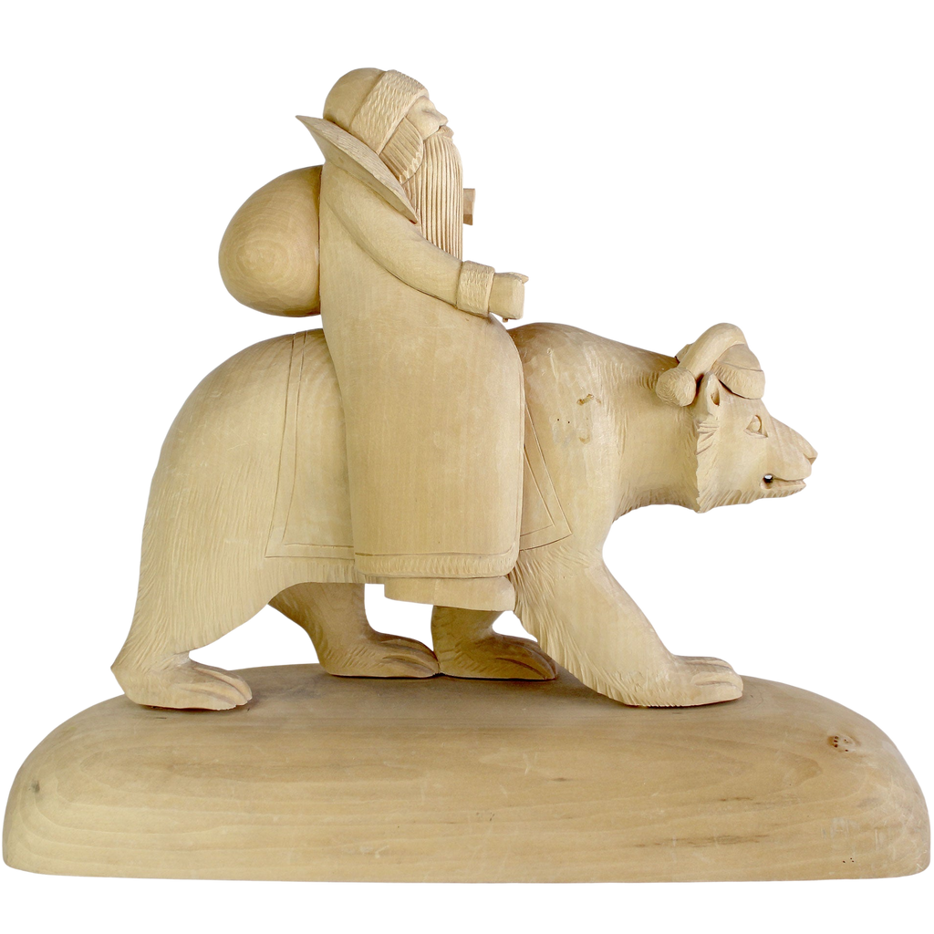 A wooden sculpture depicting a bearded figure riding a bear.