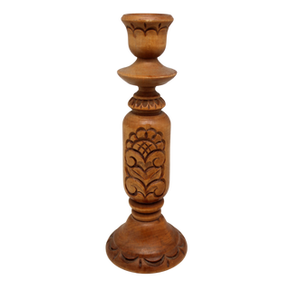 A wooden candle holder with a carved design on the front.