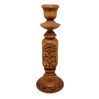 A wooden candle holder with a carved design on the front.