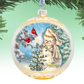 A Christmas ornament depicting a snowman with a red cardinal perched on its shoulder, surrounded by snow-covered trees and a blue sky.