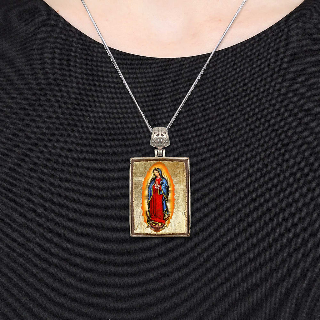 A necklace with a pendant featuring a religious figure, likely a saint or deity, in a religious iconography.