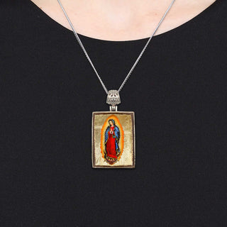 A necklace with a pendant featuring a religious figure, likely a saint or deity, in a religious iconography.