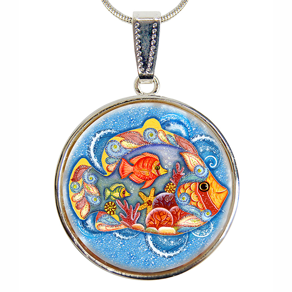 A round pendant with a painting of colorful fish swimming in a blue ocean scene.