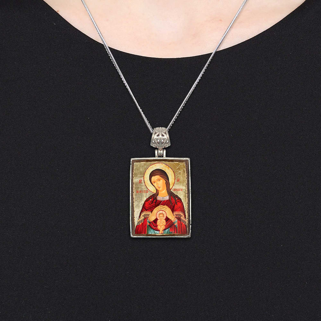 A silver necklace with a rectangular pendant featuring an image of a religious figure, such as a saint or deity.