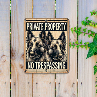 a sign with a warning about private property and no trespassing, with two dog faces on either side of the text.
