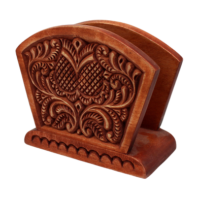 A wooden napkin holder with an intricate carved design on the back.