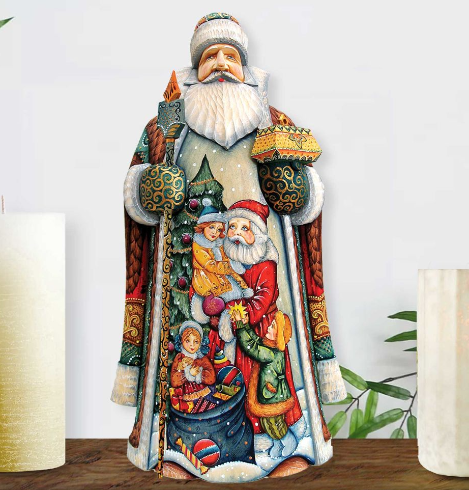 A colorful and detailed wooden sculpture of Santa Claus, with intricate designs and decorations, is displayed on a wooden surface.