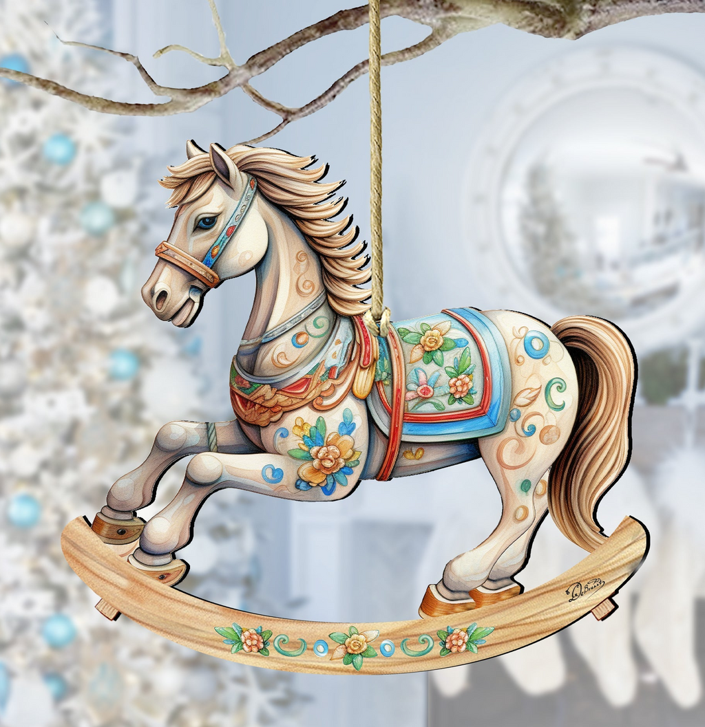 A wooden rocking horse ornament with a white horse figure and colorful floral decorations is hanging from a branch.