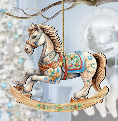 A wooden rocking horse ornament with a white horse figure and colorful floral decorations is hanging from a branch.
