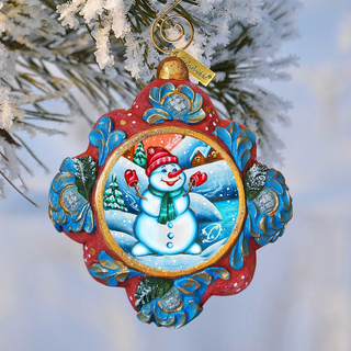 A colorful ornament featuring a snowman is hanging from a tree branch against a snowy background.