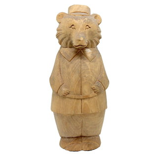A wooden sculpture of a bear wearing a top hat and coat, standing upright and facing forward.