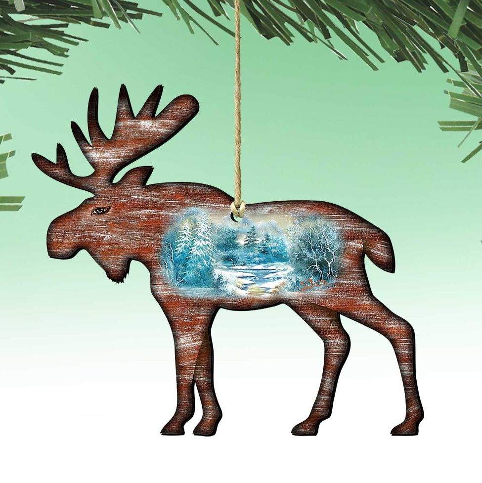 A wooden moose ornament with a winter landscape scene inside, hanging from a string.