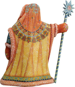 A colorful, intricately designed statue of a figure holding a staff and wearing an ornate, patterned robe.