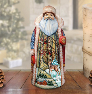 A hand-painted wooden Santa Claus figurine with a detailed winter landscape scene, including a snowy forest, a deer, and a bird.