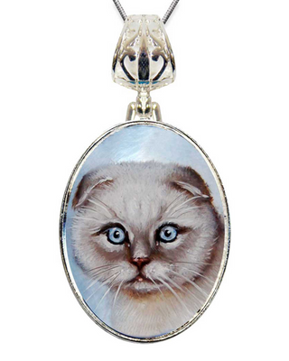 A silver pendant necklace with a round oval-shaped pendant featuring a close-up image of a cat's face.