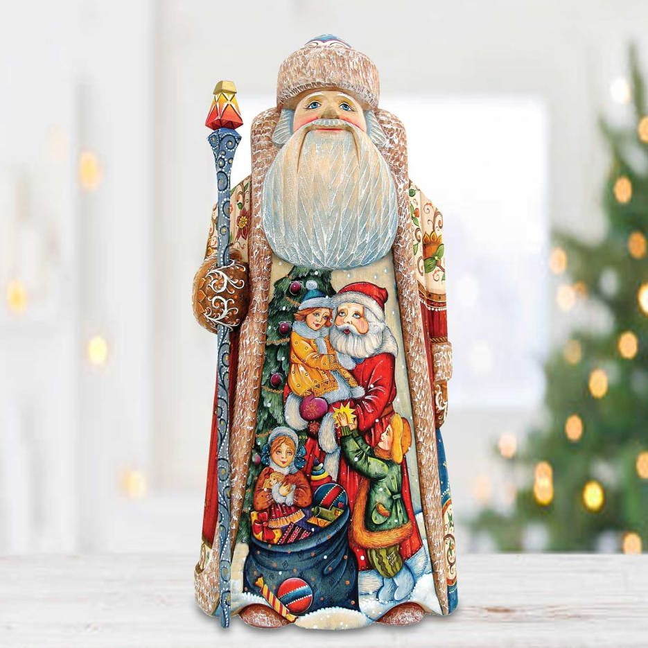 A colorful and detailed figurine of Santa Claus, with intricate patterns and designs, is displayed against a blurred background of Christmas lights.