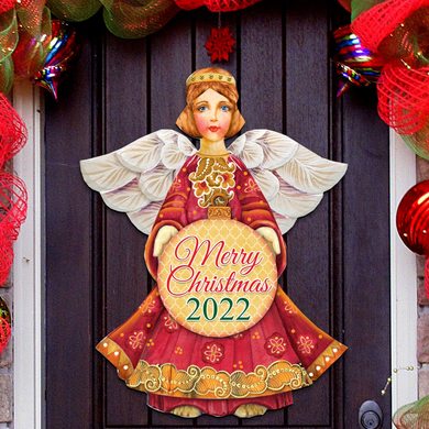 A Christmas-themed door decoration featuring a painted angel holding a 