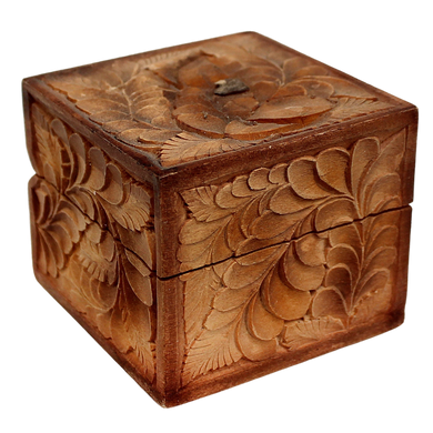 A wooden box with intricate carved designs, including leaves and flowers, on its surface.