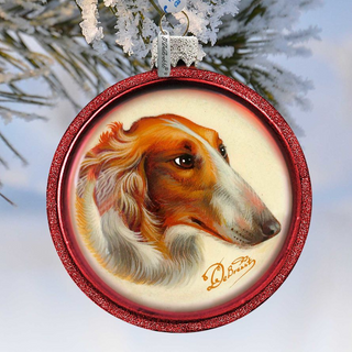 A red ornament with a picture of a dog's head, likely a Bichon Frise, hanging on a tree branch.