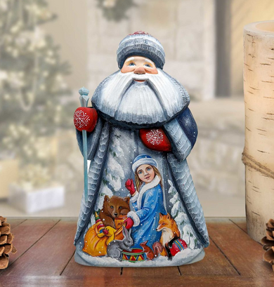 A figurine of Santa Claus holding a snowman and other winter-themed animals, including a bear, a rabbit, and a fox, on a wooden surface.