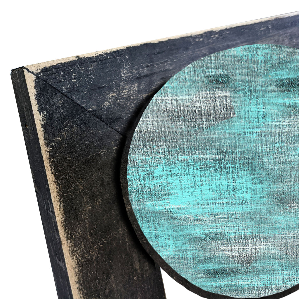 a close-up view of a wooden surface with a textured, weathered appearance. The surface appears to be a combination of black and blue colors, with a circular shape resembling a wooden frame or border. The image does not contain any text or other discernible objects or actions.