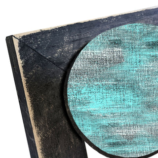 a close-up view of a wooden surface with a textured, weathered appearance. The surface appears to be a combination of black and blue colors, with a circular shape resembling a wooden frame or border. The image does not contain any text or other discernible objects or actions.