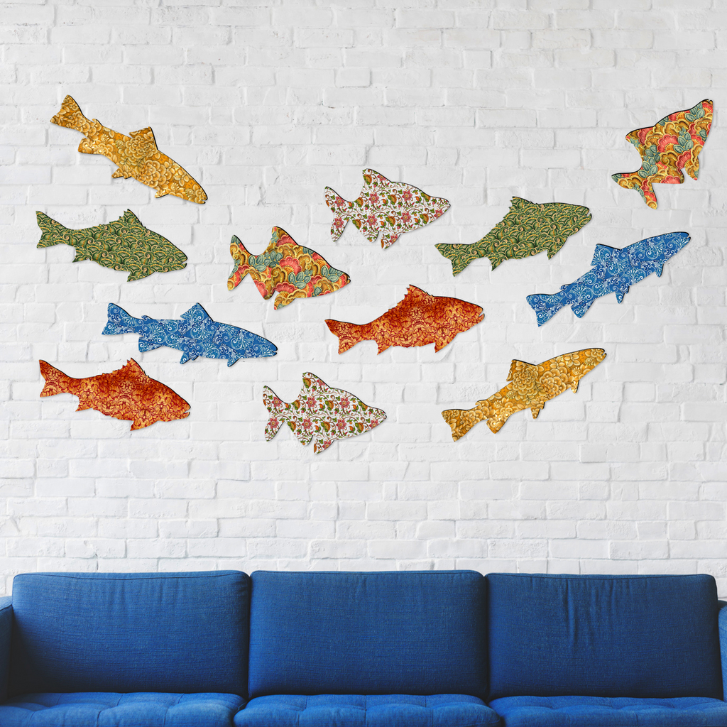 a blue couch against a white brick wall, with a collection of colorful fish-shaped cutouts displayed on the wall.