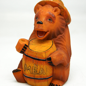 A wooden bear figurine with a hat and the word 