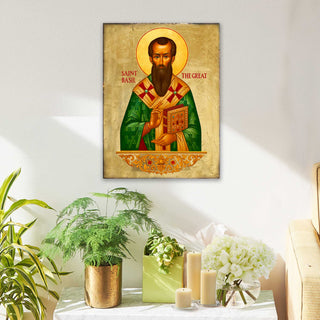 a framed illustration of Saint Basil, a famous Russian Orthodox saint, hanging on a wall above a table with potted plants and candles.