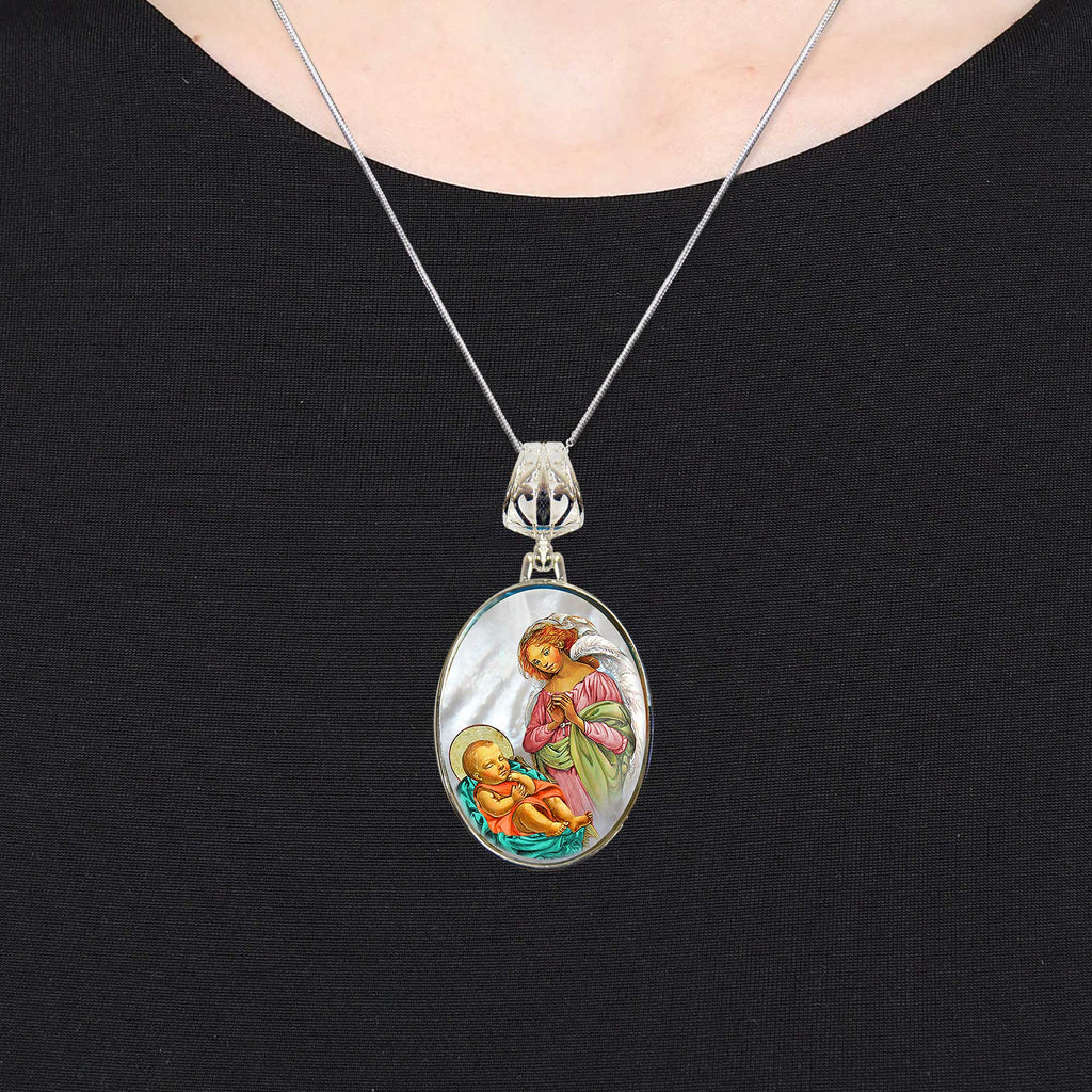 A silver necklace with a pendant featuring a religious scene of a baby being held by a woman.