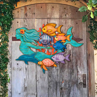 Colorful mermaid coastal wall decor with tropical fish, dolphin, and sea turtle, handcrafted by GDebrekht Artistic Studio. Made in the USA, this nautical door hanger features vivid ocean life details and weathered wood texture, perfect for coastal holiday decor, beach house accents, or undersea-themed gifts. Ideal for indoor or outdoor coastal door decorations.