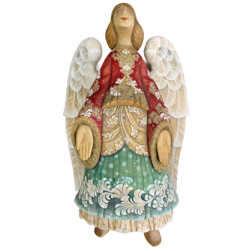 A wooden figurine of an angel with wings, wearing a red and gold dress and holding a heart-shaped object.