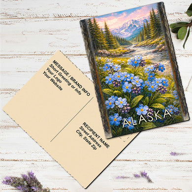 A postcard featuring a scenic landscape of a mountain range with a field of blue flowers in the foreground.