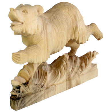 A wooden carving of a bear in mid-stride, with its mouth open and legs spread, is depicted on a wooden base.