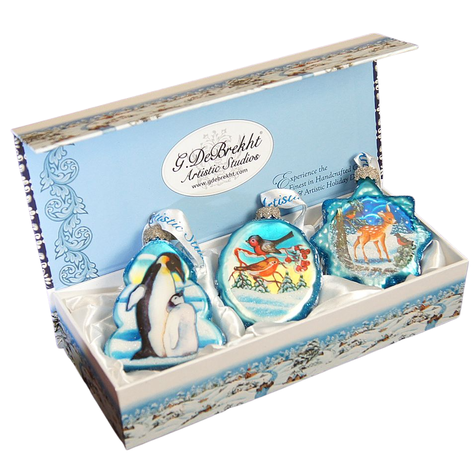 A set of three decorative ornaments in a box, each featuring a different animal and winter scene design.