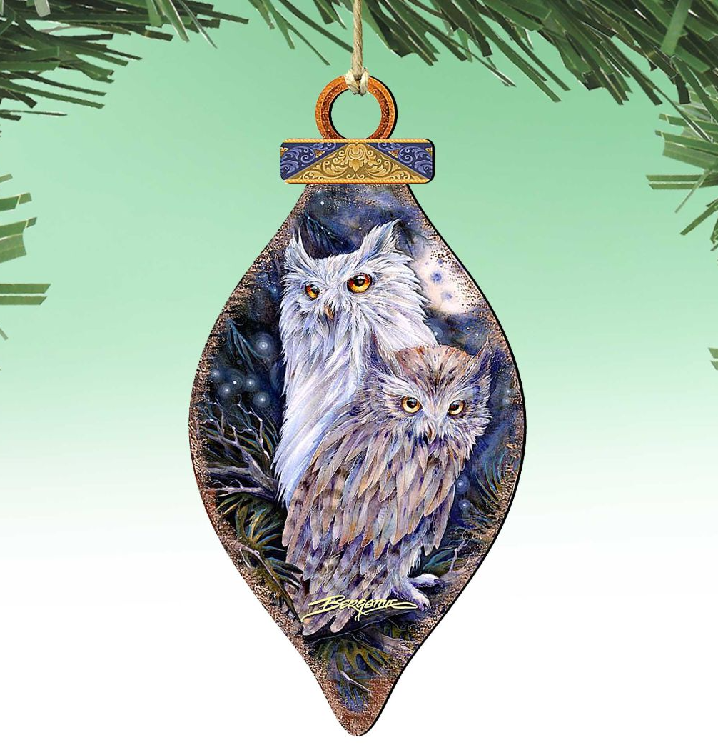 A decorative ornament featuring two owls, one larger and one smaller, against a night sky background.