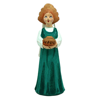 A figurine of a woman wearing a green dress and holding a basket of bread.