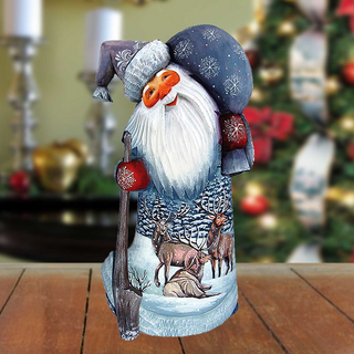 A wooden Santa Claus figurine with a snowman and reindeer design, standing on a wooden surface.